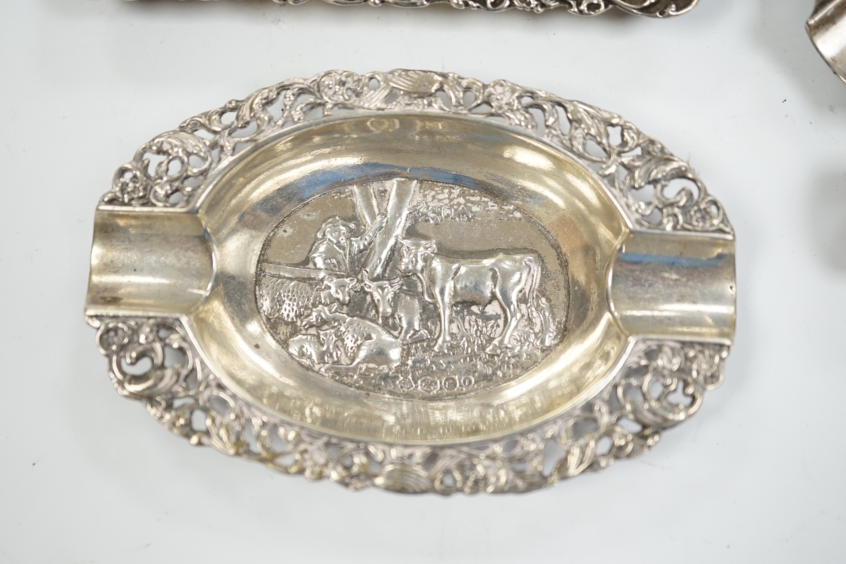A German pierced 800 white metal oval dish, 28.4cm, three Dutch white metal ashtrays and an 835 white metal lighter.
